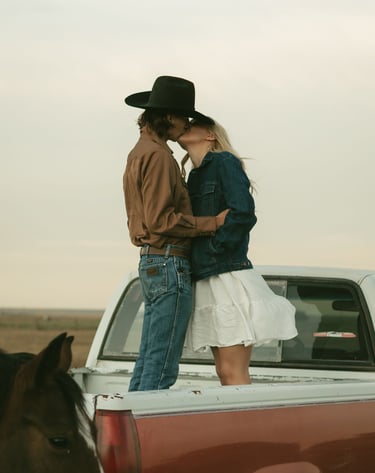 a man and woman kissing in the back of a truck