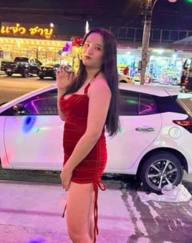 lady wearing short red dress with a white car in the background