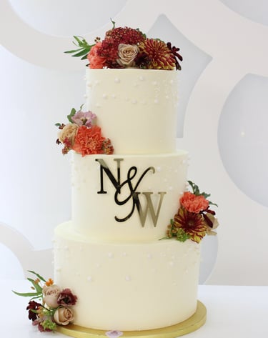 Tarta de boda personalizada de tres pisos con flores naturales, elaborada artesanalmente en Madrid