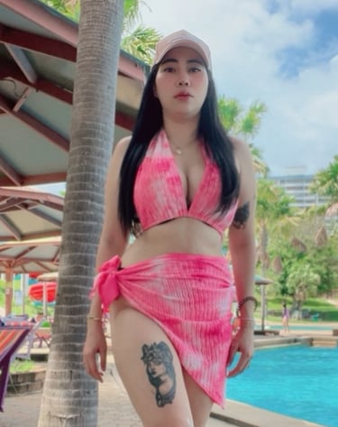 lady standing by swimming pool with a pink bikini and sarong