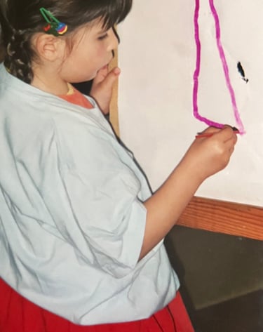 a young girl is holding a piece of paper and a pencil