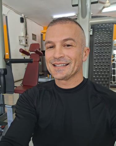 Man wearing black top sitting in a gym