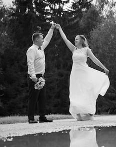 a bride and groom holding hands in a puddle of water