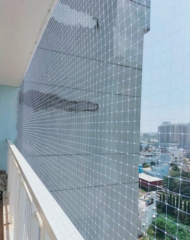 Technician from Arjilli Enterprises carefully fitting a safety net on a rooftop edge.