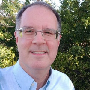 a man in a blue shirt and glasses