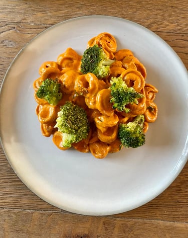 a plate of pasta with broccoli and cheese