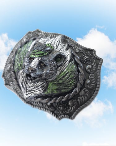 Vintage silver western belt buckle featuring a detailed skunk design against a blue sky background.