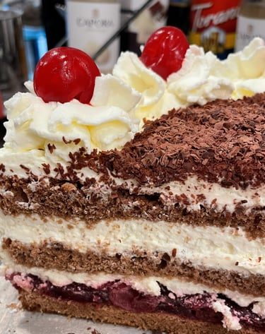 a piece of Black Forest cake with cherries on top of it