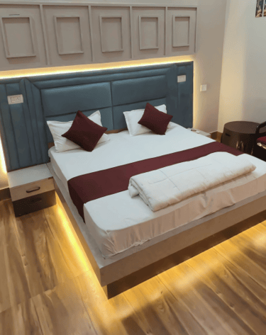 a bed with a bed and a chair - Rasa veda Hotel  Shikohabad