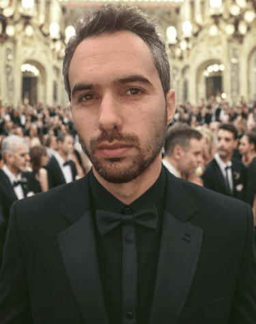 a man in a tuxedo suit and bow tie his name is Karim Lazaar