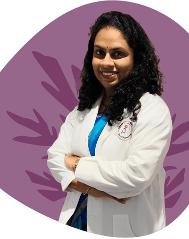 Smiling female healthcare professional wearing a white lab coat with arms crossed on a purple background.
