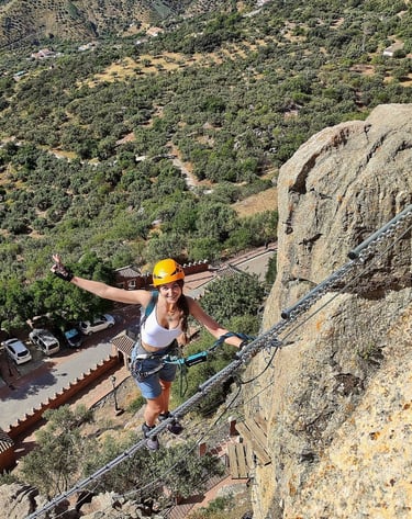 Aventurera subiendo escalera al cielo en la vía ferrata El Turrión