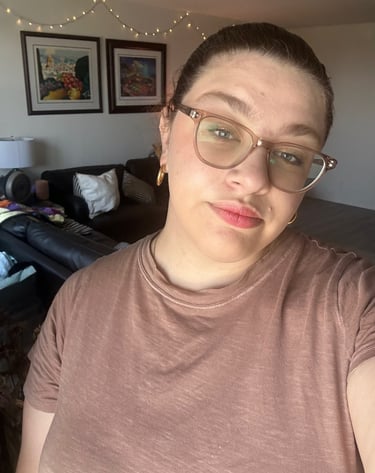 a woman with glasses and a brown shirt