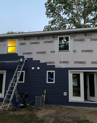Old siding replacement in process with new durable siding on residential home
