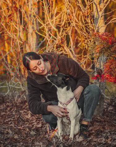 una ragazza guarda il suo cane su un suolo di foglie secche
