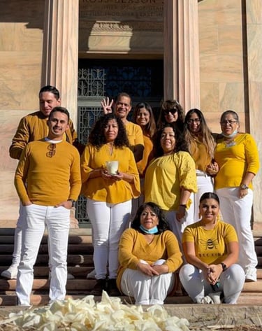 A group of people wearing yellow shirts and white pants pose for a photo at the Utah State Capitol.