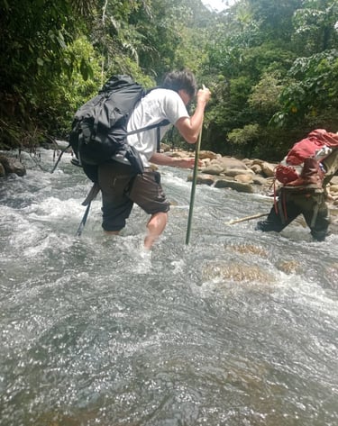 a man in a backpacker with a backpacker crossing the river 