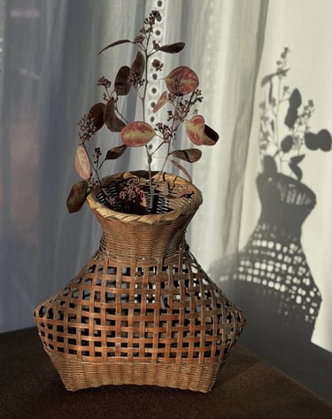 A small black and white toy poodle puppy lying on a couch with a chew toy.