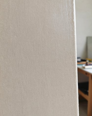A detailed close-up shot of the corner of a painting, capturing the subtle texture of the linen canvas and the refined application of light beige and grey-taupe paint. Soft, natural morning light in a contemporary studio.