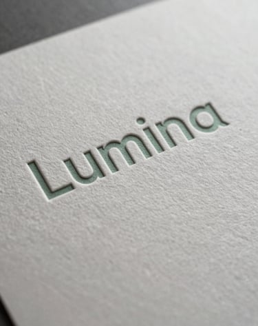 An extreme close-up photograph focusing on the texture of a custom-embossed Lumina label. The paper is a textured Off-White with subtle Soft Sage ink. The lighting is dramatic, emphasizing the strategic craftsmanship of the print finish in a North American / US production facility.