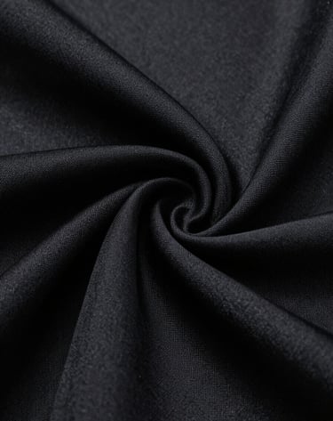 Macro photography showing the intricate texture of a black silk fabric draped elegantly. The lighting highlights the sheen and sophisticated weave, creating an atmosphere of tactile luxury. Black and dark grey tones. Cinematic style.