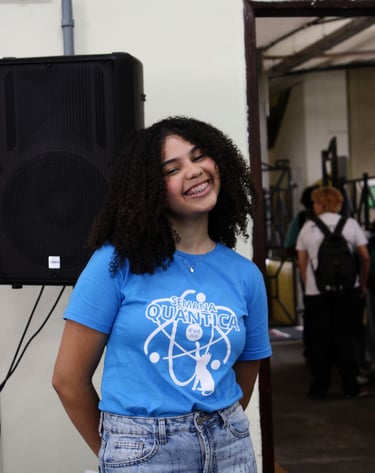 Foto de Ana Terra, Secretária Administrativa do clube POLIS IFBA, sorrindo no campus universitário e