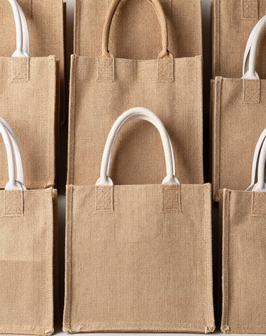 Rows of finished bags drying on a rustic wooden rack, showcasing bold patterns.