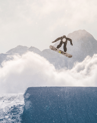 a snowboarder is doing a trick on a ramp