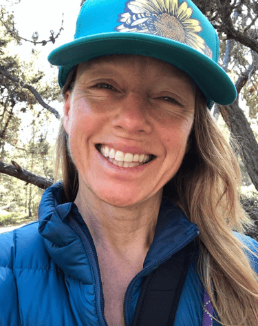 Jamie wearing hat in the woods smiling 2