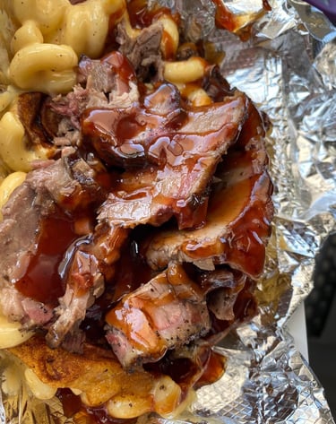 Signature One Eye Willy brisket mac and cheese—Texas-style smoked brisket over four-cheese macaroni with BBQ drizzle, served 
