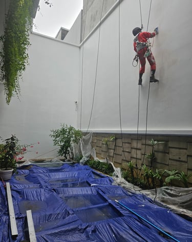 a man climbing up a wall on a rope