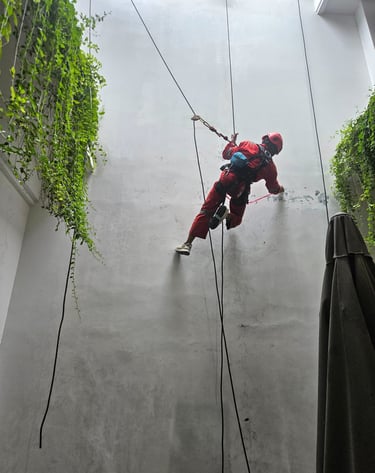 a man in a red suit is climbing on a rope