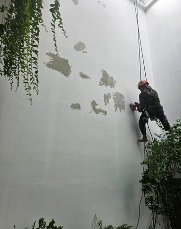 a man climbing up a wall with a rope
