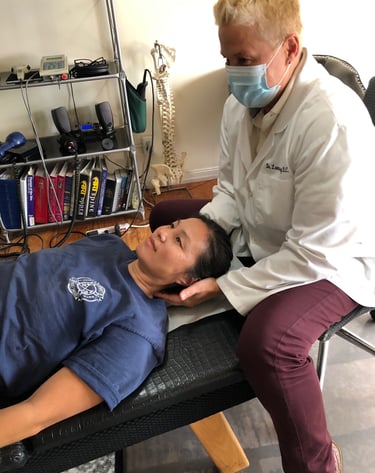 Dr. Lonna Denny performing traditional neck adjustment to one of her patients.