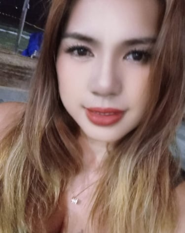 Experienced home massage therapist in Pattaya with a friendly and welcoming appearance, photographed in a night market