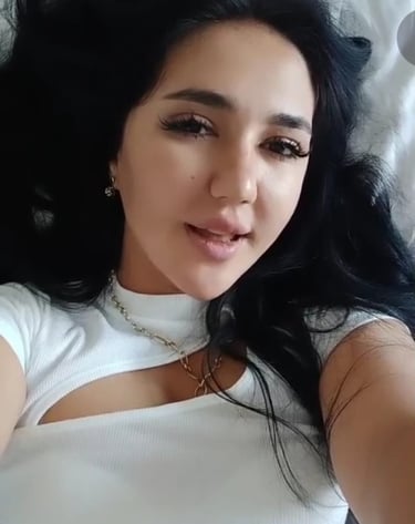 lady therapist lying on bed with white dress taking a selfie
