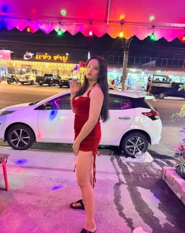 lady wearing short red dress with a white car in the background
