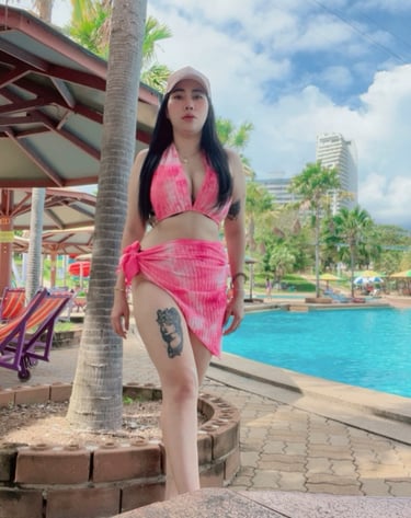 lady standing by swimming pool with a pink bikini and sarong