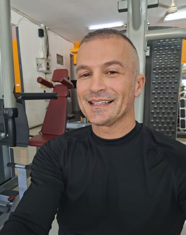 Male therapist wearing black top sitting in a gym