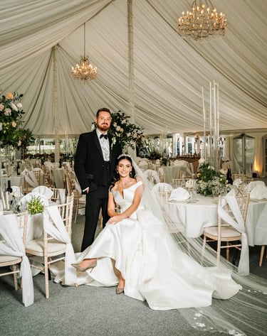 Bride and groom in an elegant white wedding marquee