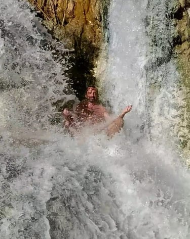 a man meditating in a waterfall in the middle of a waterfall