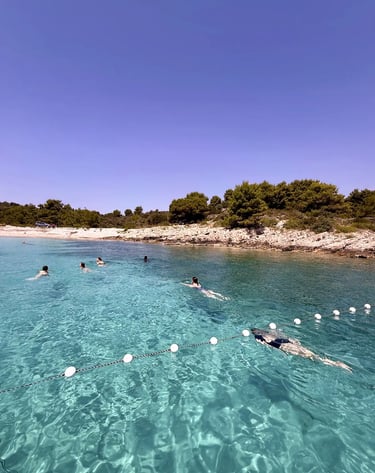 Girls swimming and diving in crystal-clear water at Solinska Bay Drvenik Veliki Croatia during a private boat trip from Split