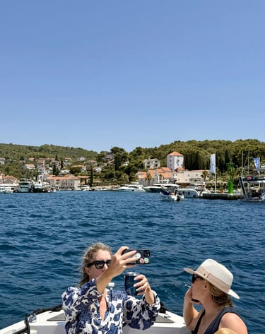 Woman taking a selfie at the coastline of Maslinica on Solta, Croatia from a boat on a private half-day tour from Split