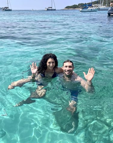 Couple swimming and waving in the turquoise waters of the Blue Lagoon during a boat trip from Split