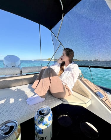 Guest relaxing on the stern sundeck of Hunter Pro 800 RIB with sunshade and drinks during a private boat tour from Split.