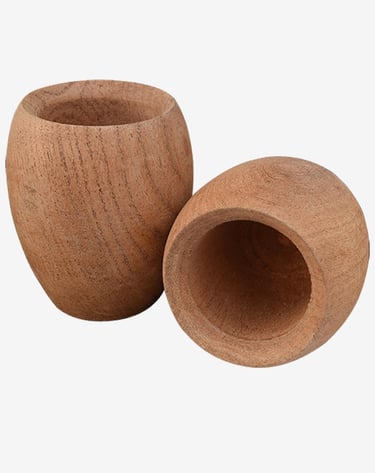 Two small hand-carved natural wooden cups with visible grain on a white background.