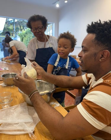 um homem e uma criança com a avó na cozinha