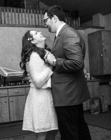 a bride and groom dancing while looking at one another