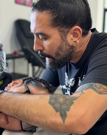 Tattoo Artist Ruben Enriquez while doing a tattoo on a client