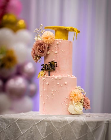 a cake with a yellow ribbon and flowers on it